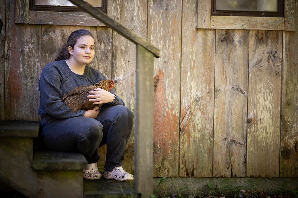 Animal Husbandry. Girl with chicken on stairs